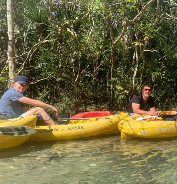 OCEAN KAYAK in lush jungle waterways with two people enjoying outdoor adventure, nature exploration, and water sports on a sunny day.